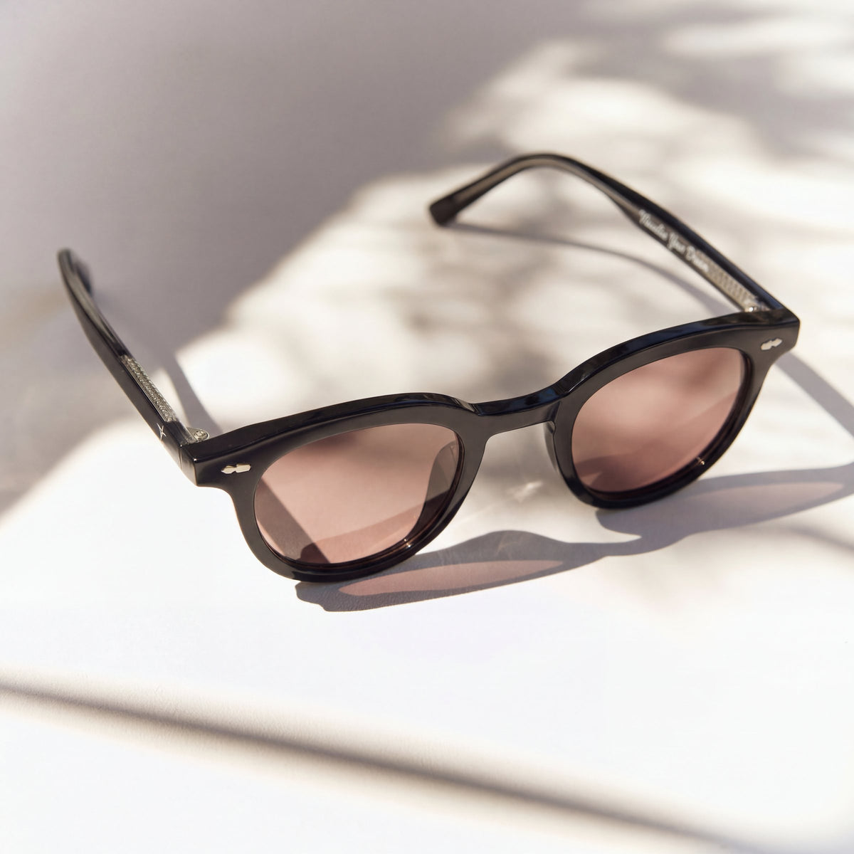 Noxie Black/Red sunglasses, black round frame with rose-tinted lenses