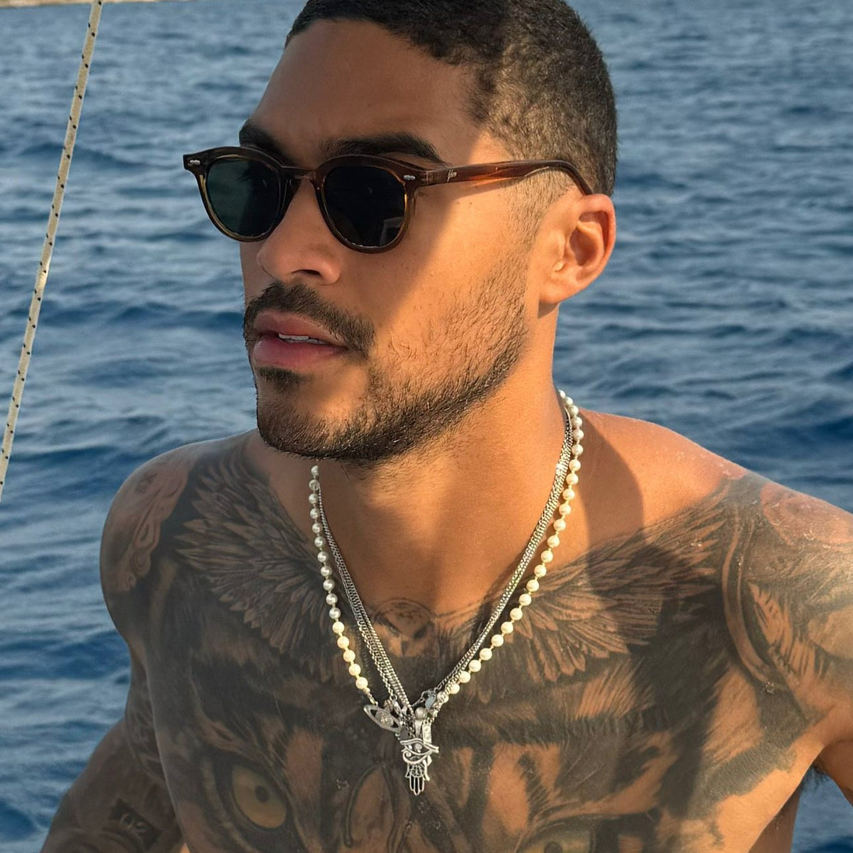 Man wearing Noxie Brown/Green sunglasses on a boat at sea