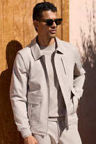 Man wearing Celuna Olive square sunglasses with a stone zip jacket