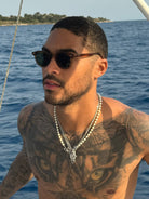 Man wearing Noxie Brown/Green sunglasses on a boat at sea